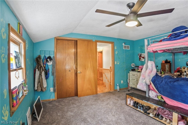 bedroom featuring a textured ceiling, ceiling fan, carpet floors, and lofted ceiling