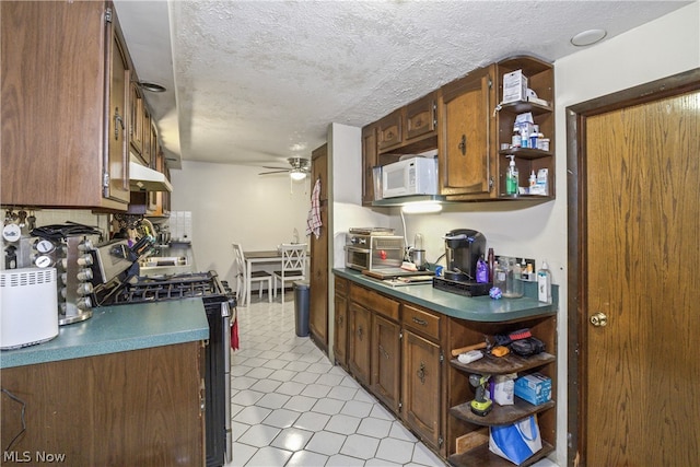 kitchen with a textured ceiling, ceiling fan, light tile floors, and range with gas cooktop