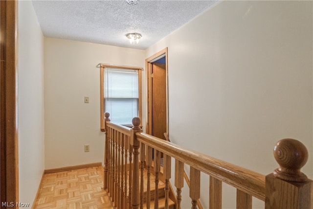 hall with light parquet flooring and a textured ceiling