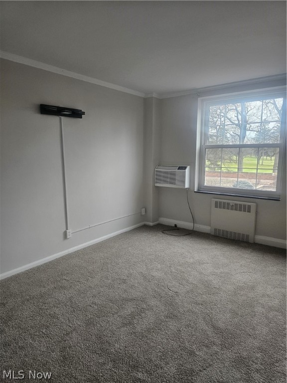 carpeted spare room featuring crown molding, radiator heating unit, and a wall mounted AC