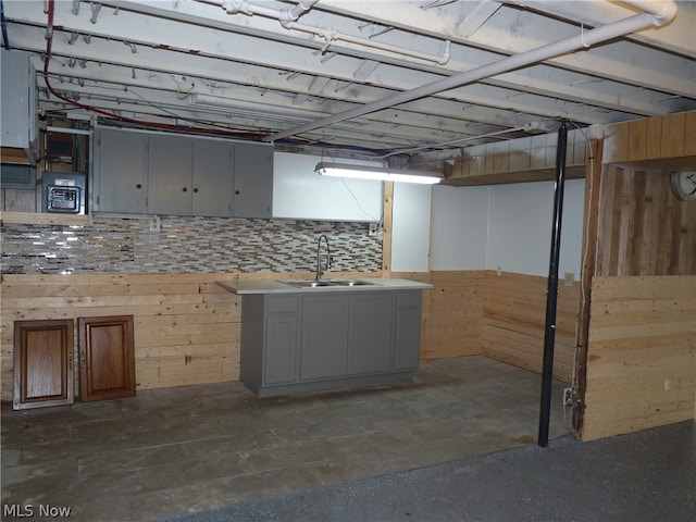 basement featuring sink and dark tile patterned flooring