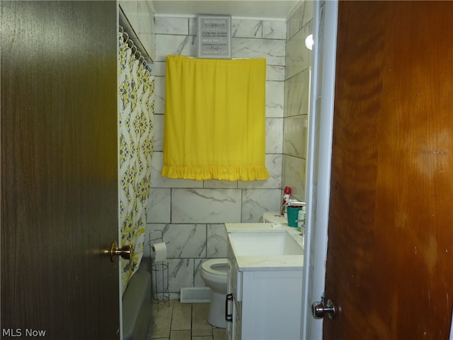 full bathroom featuring shower / bath combination with curtain, tile walls, tile patterned floors, toilet, and vanity