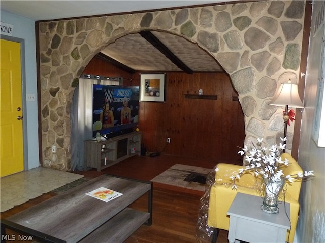 living room featuring lofted ceiling, hardwood / wood-style flooring, and wooden walls