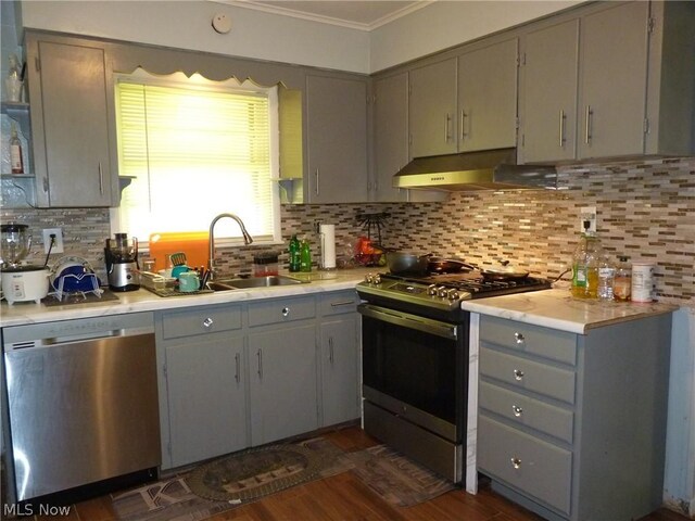 kitchen featuring dishwasher, wall chimney exhaust hood, range with gas stovetop, and backsplash