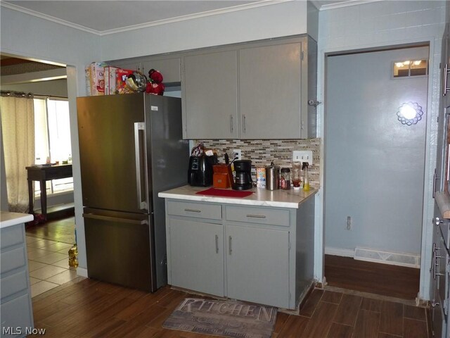 kitchen featuring dark hardwood / wood-style floors, stainless steel fridge, tasteful backsplash, and gray cabinetry