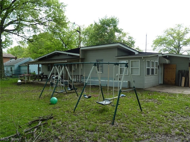 rear view of house with a playground and a lawn