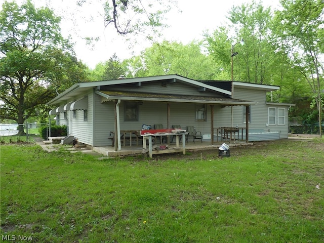 rear view of house featuring a yard