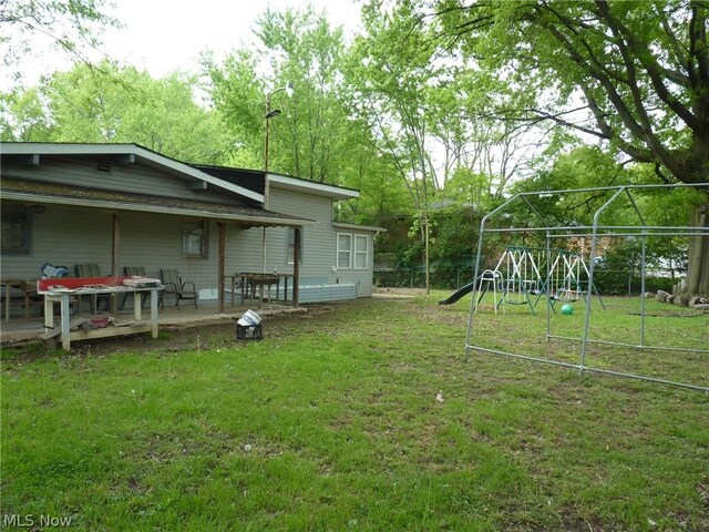 view of yard featuring a deck and a playground