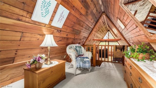 sitting room featuring wood ceiling, carpet flooring, wooden walls, and vaulted ceiling with beams