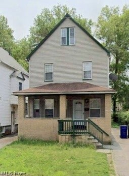 view of front of house with covered porch and a front lawn