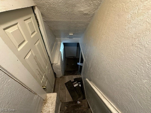 stairway with a textured ceiling