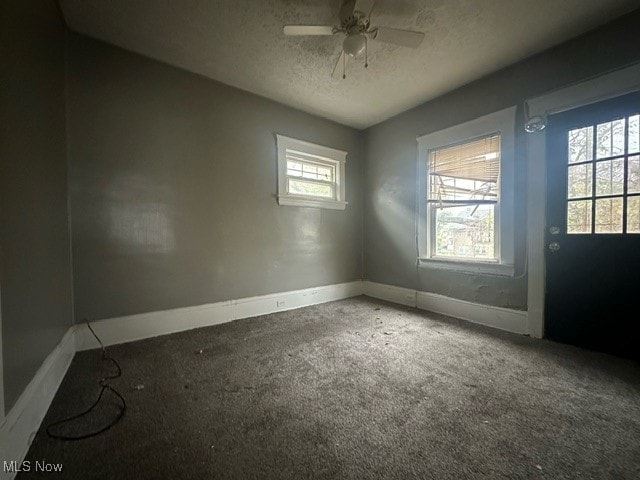 unfurnished room featuring carpet, a textured ceiling, and ceiling fan