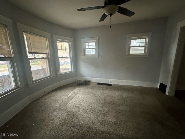 carpeted empty room featuring a wealth of natural light and ceiling fan