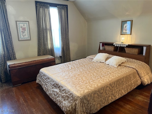 bedroom featuring dark hardwood / wood-style flooring and vaulted ceiling