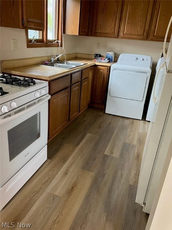 kitchen featuring washer / dryer, wood-type flooring, sink, and gas range gas stove