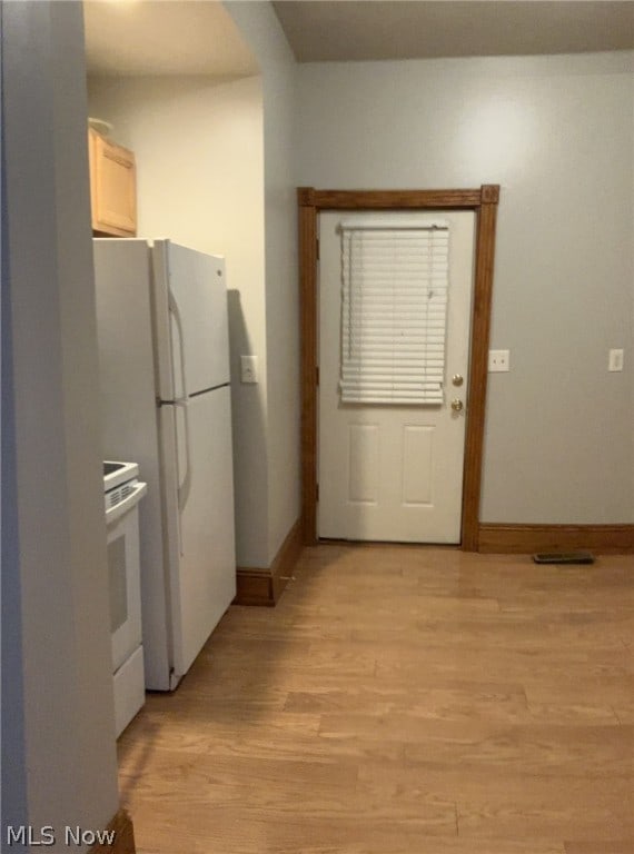 kitchen with light hardwood / wood-style flooring and white appliances