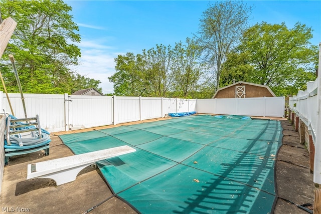 view of pool featuring a diving board and an outdoor structure