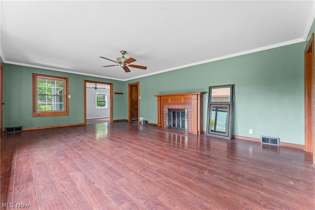 unfurnished living room with hardwood / wood-style floors, ceiling fan, ornamental molding, and a brick fireplace