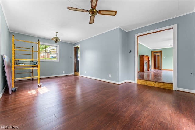 interior space with dark wood-type flooring, ceiling fan with notable chandelier, and ornamental molding