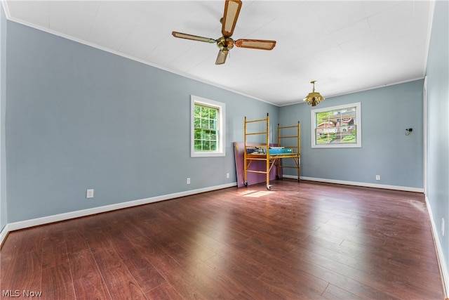 empty room with dark wood-type flooring, ceiling fan, and ornamental molding