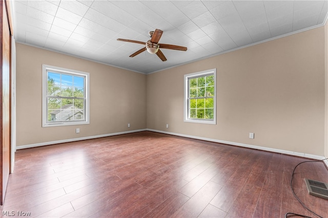 unfurnished room with wood-type flooring, a healthy amount of sunlight, and ornamental molding