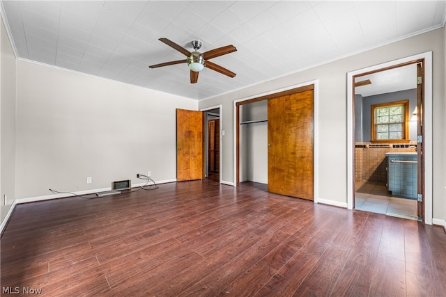 unfurnished bedroom with ornamental molding, ceiling fan, and dark hardwood / wood-style floors