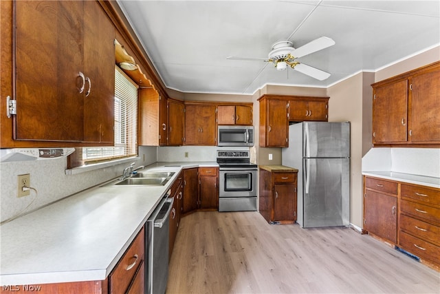 kitchen featuring appliances with stainless steel finishes, decorative backsplash, sink, ceiling fan, and light hardwood / wood-style flooring