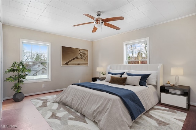 bedroom featuring ornamental molding, wood-type flooring, and ceiling fan