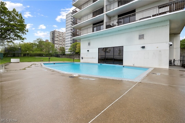 view of pool featuring a lawn