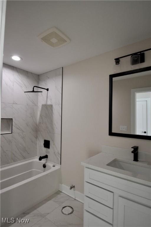 bathroom with vanity and tiled shower / bath