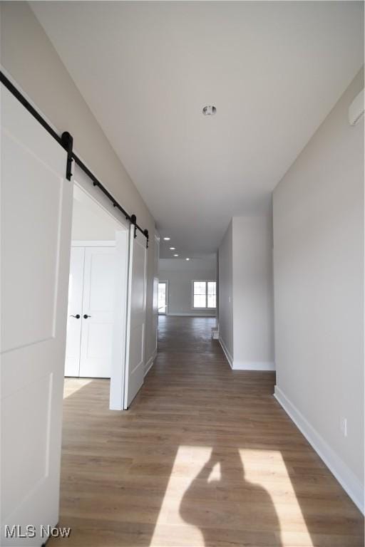 hall with hardwood / wood-style flooring and a barn door