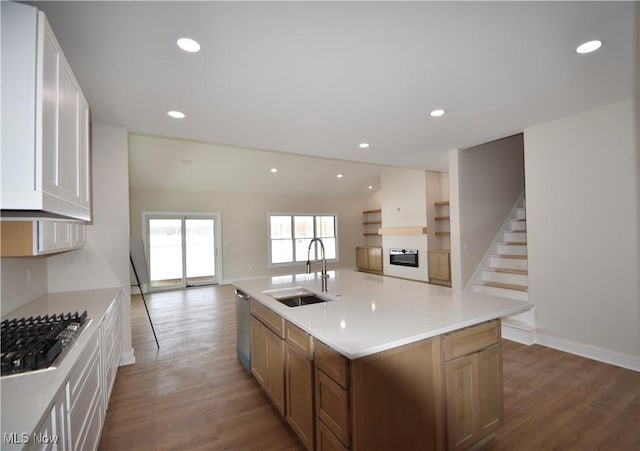 kitchen featuring sink, hardwood / wood-style flooring, white cabinetry, stainless steel appliances, and an island with sink