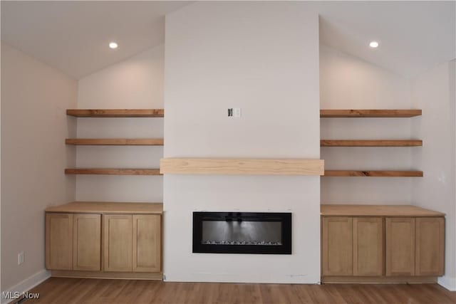 unfurnished living room with vaulted ceiling and light hardwood / wood-style flooring