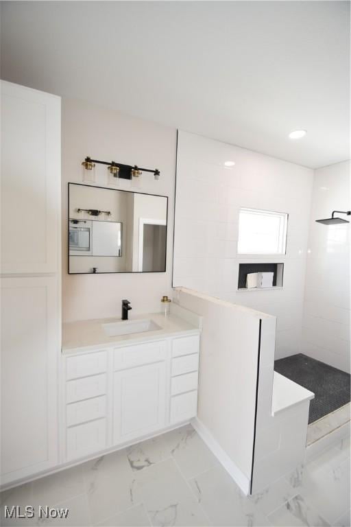 bathroom with vanity and a shower