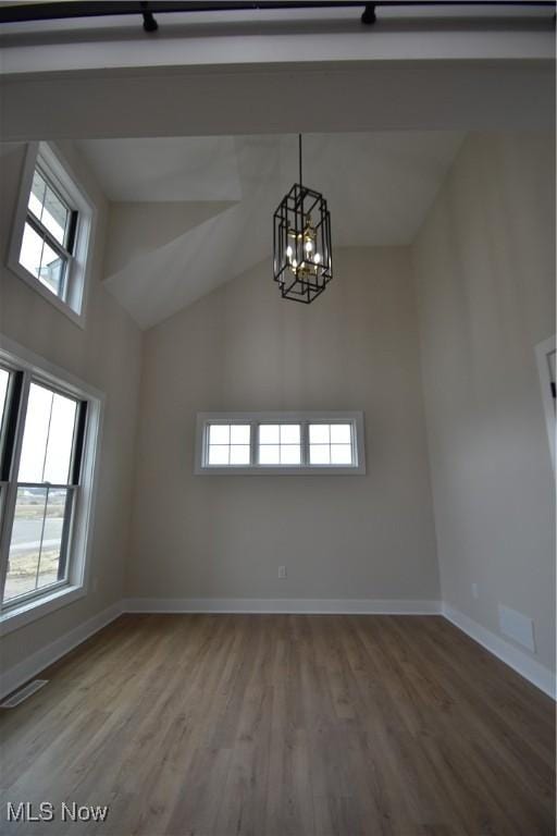 spare room with visible vents, baseboards, and wood finished floors