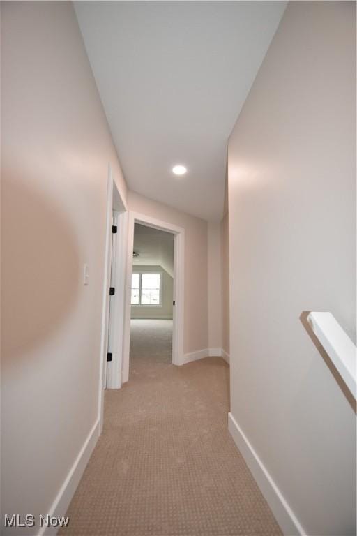 hallway with recessed lighting, light colored carpet, and baseboards