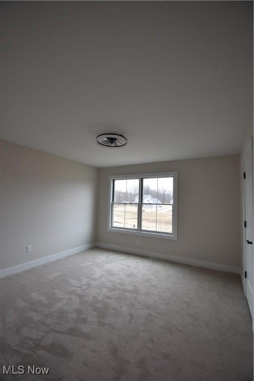 unfurnished room with carpet and baseboards