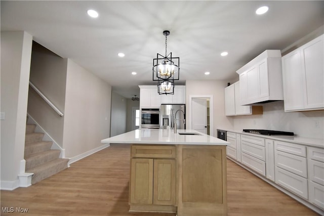 kitchen with stainless steel appliances, recessed lighting, light countertops, light wood-style floors, and a sink