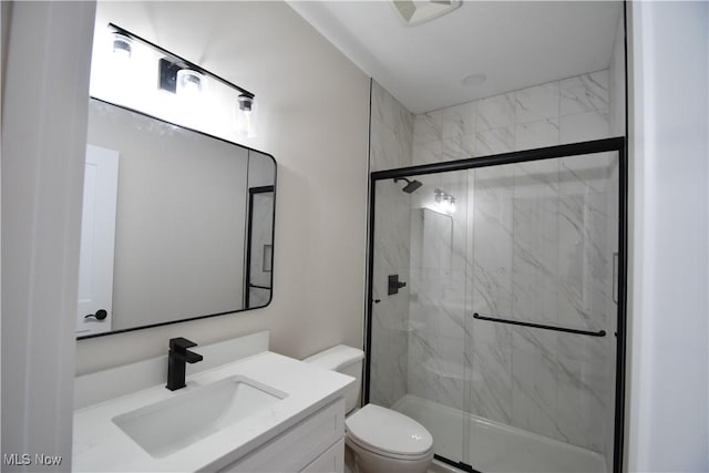 bathroom with toilet, vanity, and a marble finish shower