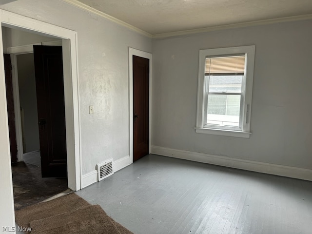 empty room with hardwood / wood-style floors and ornamental molding