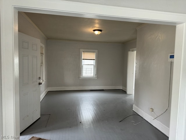 spare room featuring dark hardwood / wood-style flooring and crown molding