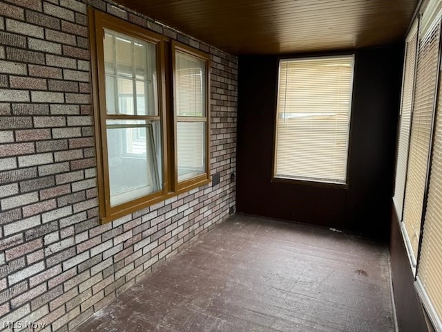 spare room with wooden ceiling, brick wall, and hardwood / wood-style floors