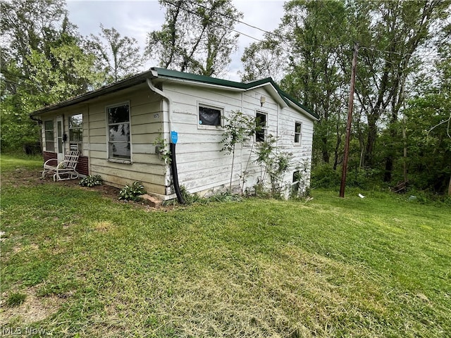 view of side of home with a yard