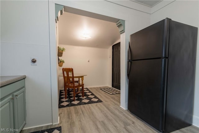 kitchen with black fridge, lofted ceiling, and light hardwood / wood-style flooring