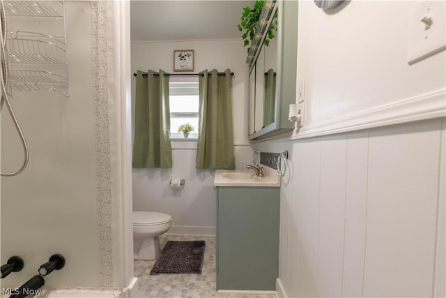 bathroom featuring tile patterned flooring, vanity, toilet, and walk in shower