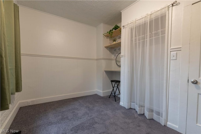 carpeted empty room with a textured ceiling