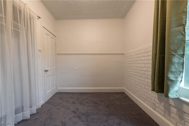 carpeted spare room with a textured ceiling