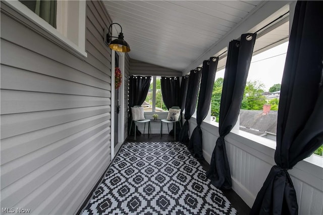 sunroom with plenty of natural light and lofted ceiling