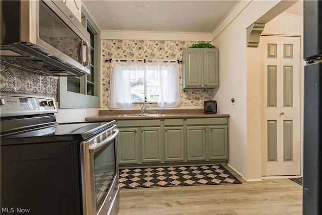 kitchen with crown molding, sink, light hardwood / wood-style flooring, a textured ceiling, and stainless steel appliances