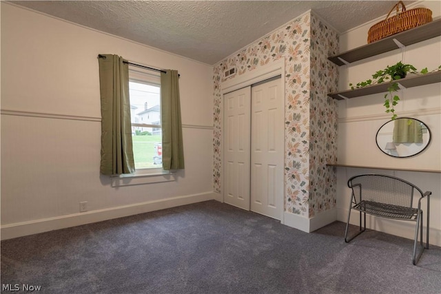 unfurnished bedroom featuring dark carpet and a textured ceiling